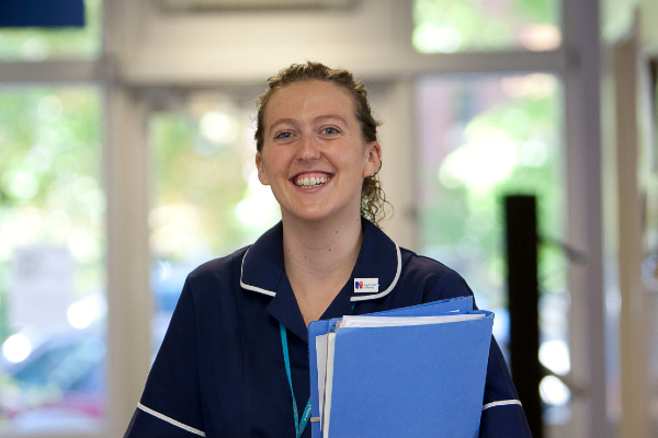 Smiling nurse with folder