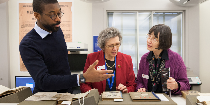 staff member showing two women some historic books