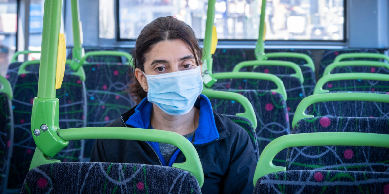 woman with mask sitting on a bus 
