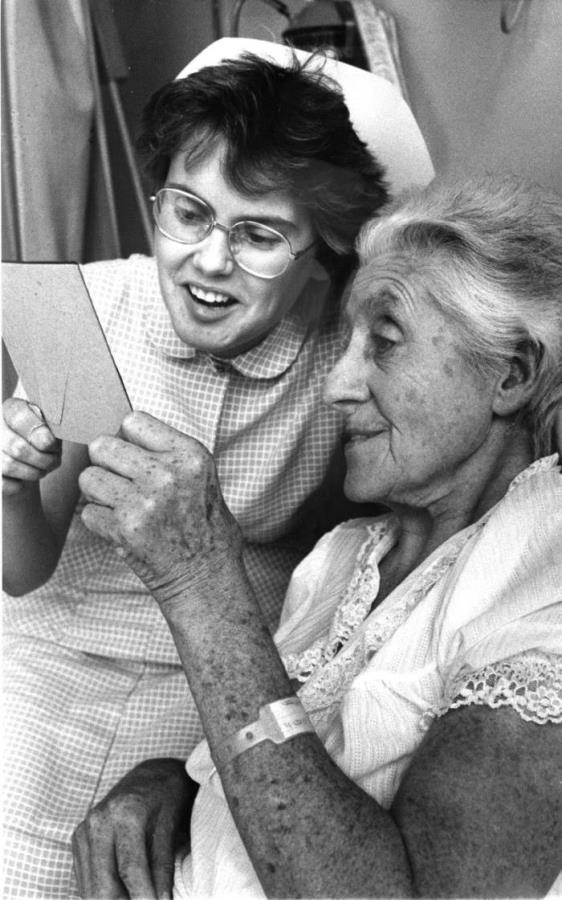 Nurse and an older adult patient on a hospital ward, c.1980. RCN Archive.