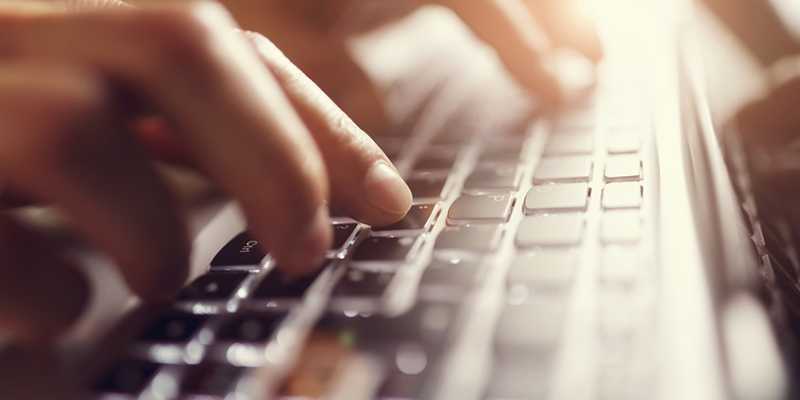 Close up of hands typing on a laptop